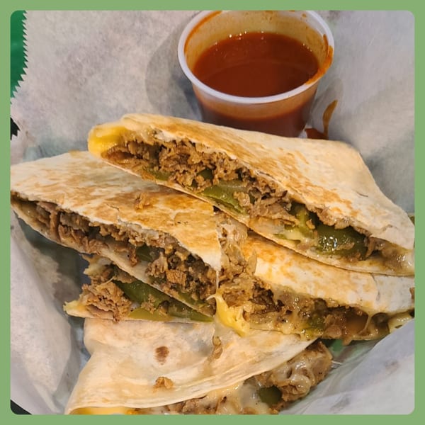 Santa Fe Taco Company's quesadilla with steak, green peppers, onions, and melted cheese, with a side of salsa.